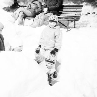 Family enjoying snow play outdoors.