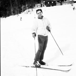 Person cross-country skiing in snowy forest.