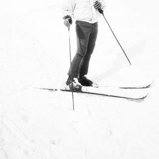 Person cross-country skiing in snowy forest.