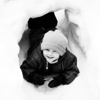 Child happily buried in snow.