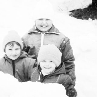 Three people playing in deep snow.