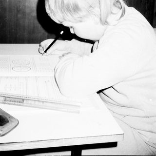 A young girl drawing with a ruler.