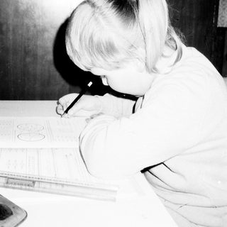 A young girl drawing with a ruler.