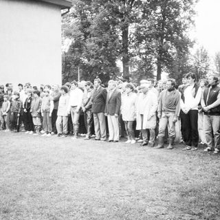 Group of people standing in line outdoors.
