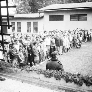 Long line of people queuing outside a building.