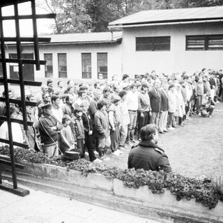 Long line of people queuing outside a building.