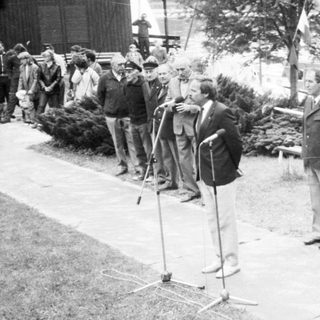 Group of men in formal attire saluting during a ceremony.
