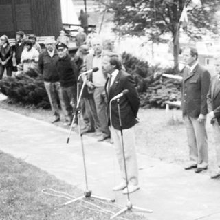 Group of men in formal attire at outdoor ceremony.