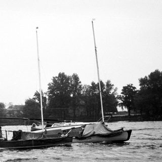 Small sailboats anchored on a body of water.