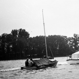 Two boats on water, one sailboat and one motorboat.
