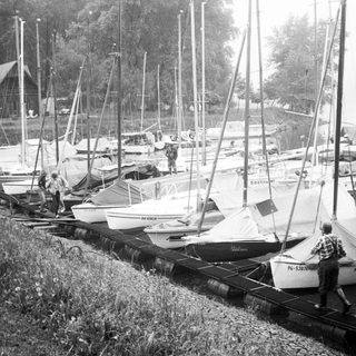 Marina with row of sailboats on trailers.