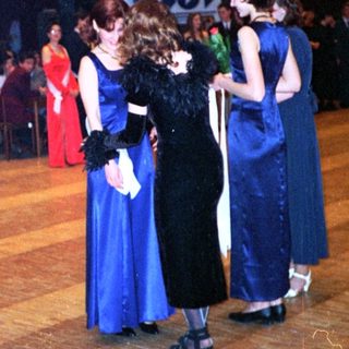 Prom or formal school dance with students in 1980s attire.