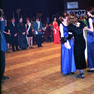 Prom or formal school dance with students in 1980s attire.