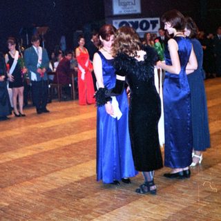 Prom or formal school dance with students in 1980s attire.