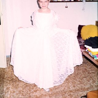 Young girl wearing a white lace wedding dress.