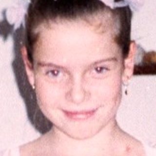 Young girl wearing a white lace wedding dress.