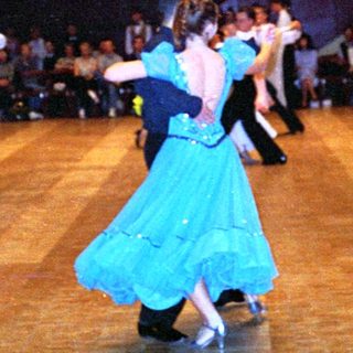 Ballroom dance competition with participants in formal attire.
