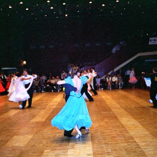Ballroom dance competition with participants in formal attire.