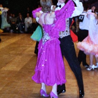 Ballroom dance competition or exhibition with participants in formal attire.