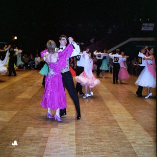 Ballroom dance competition or exhibition with participants in formal attire.