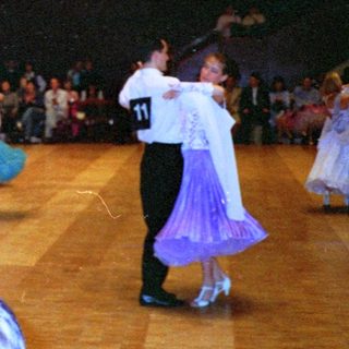 Ballroom dance competition with numbered participants.