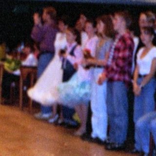 Ballroom dance competition with performers on wooden floor.