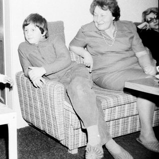 Family moment indoors with children and elderly woman.