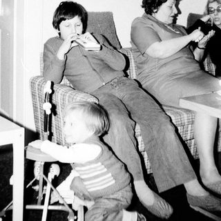 Family gathering indoors with adults and child eating.