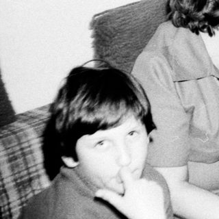 Family gathering indoors, playing board game.