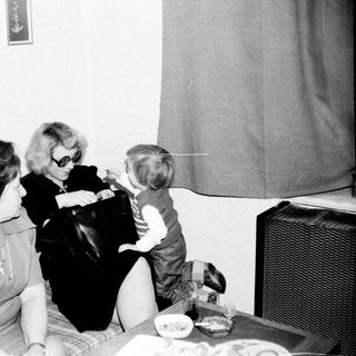 Family gathering indoors, playing board game.