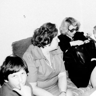 Family gathering indoors, playing board game.