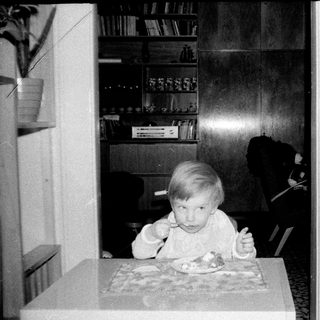 Two children eating indoors during a meal.