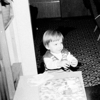 Two children sitting indoors, watching television.