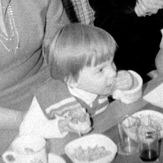 Family gathering enjoying tea and desserts indoors.