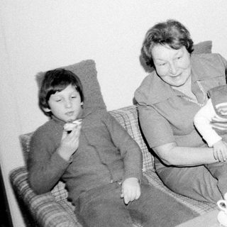 Family gathering indoors with tea and snacks.