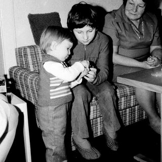 Family members playing card game indoors.