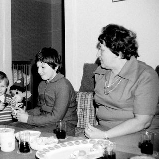 Family enjoying tea time with children playing.