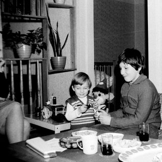 Family enjoying tea time with children playing.
