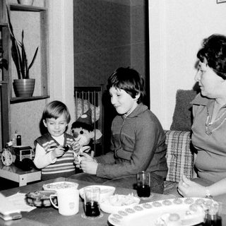 Family enjoying tea time with children playing.