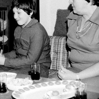 Family enjoying tea time with children playing.