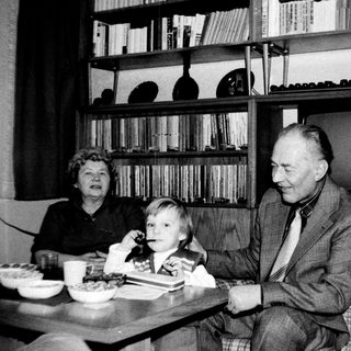 Family sharing a meal indoors during the 1960s-70s.