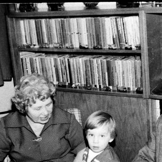 Family trio enjoying indoor gathering with television.