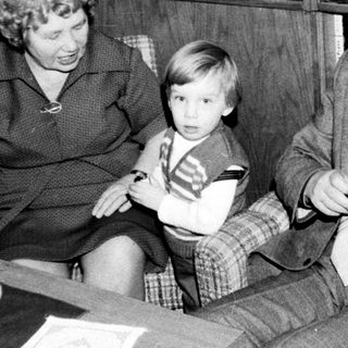 Family trio enjoying indoor gathering with television.