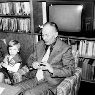 Family trio enjoying indoor gathering with television.