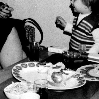 Family meal scene with two adults and a young child.