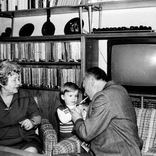 Family sharing a moment indoors with old television.