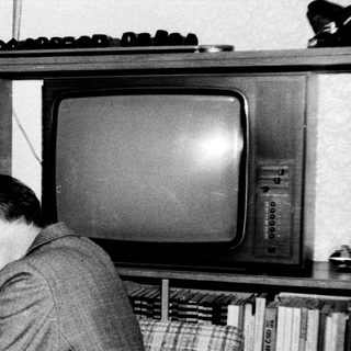 Family sharing a moment indoors with old television.