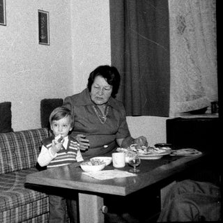 Family sharing meal indoors during the 1970s-80s.