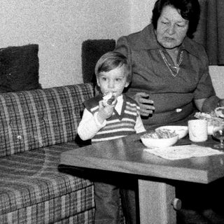 Family sharing meal indoors during the 1970s-80s.