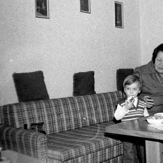 Family sharing meal indoors during the 1970s-80s.